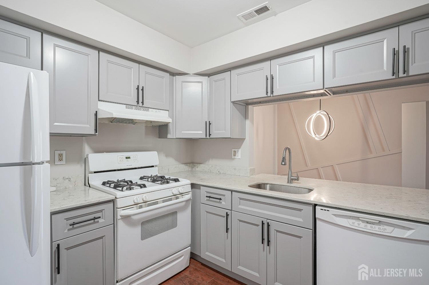 a kitchen with white cabinets and white appliances