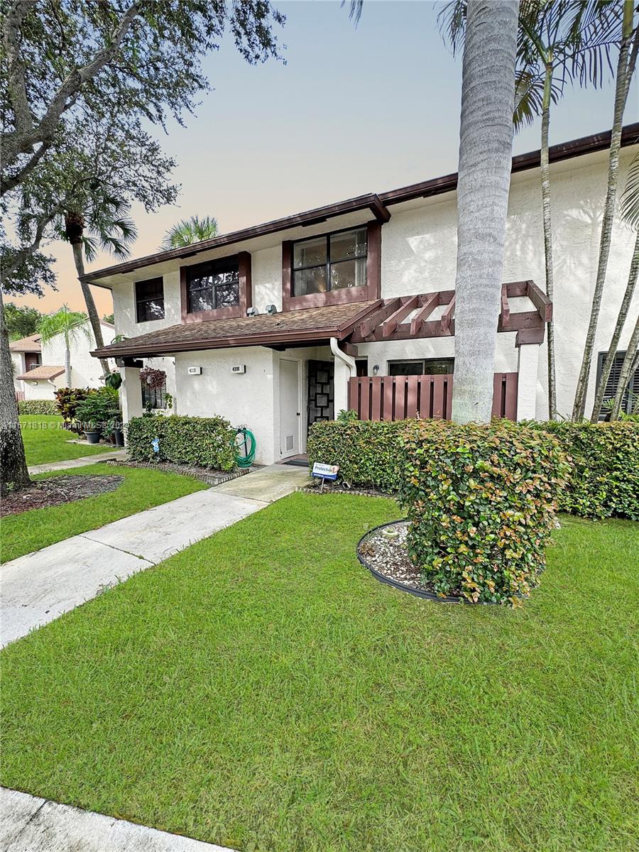 a front view of a house with a garden