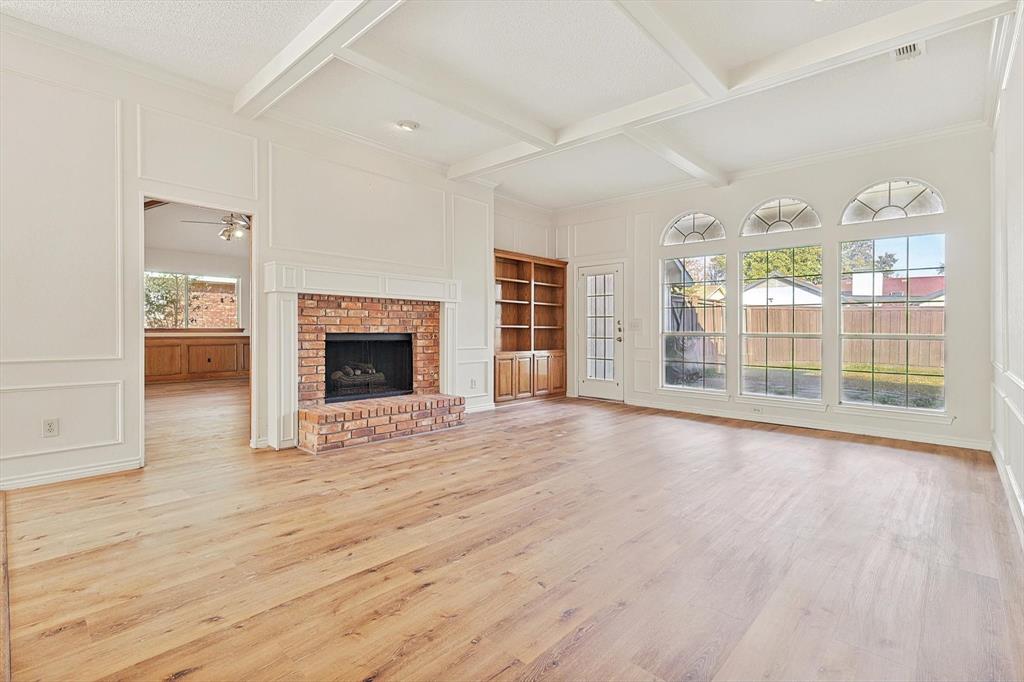 a view of an empty room with glass door and wooden floor