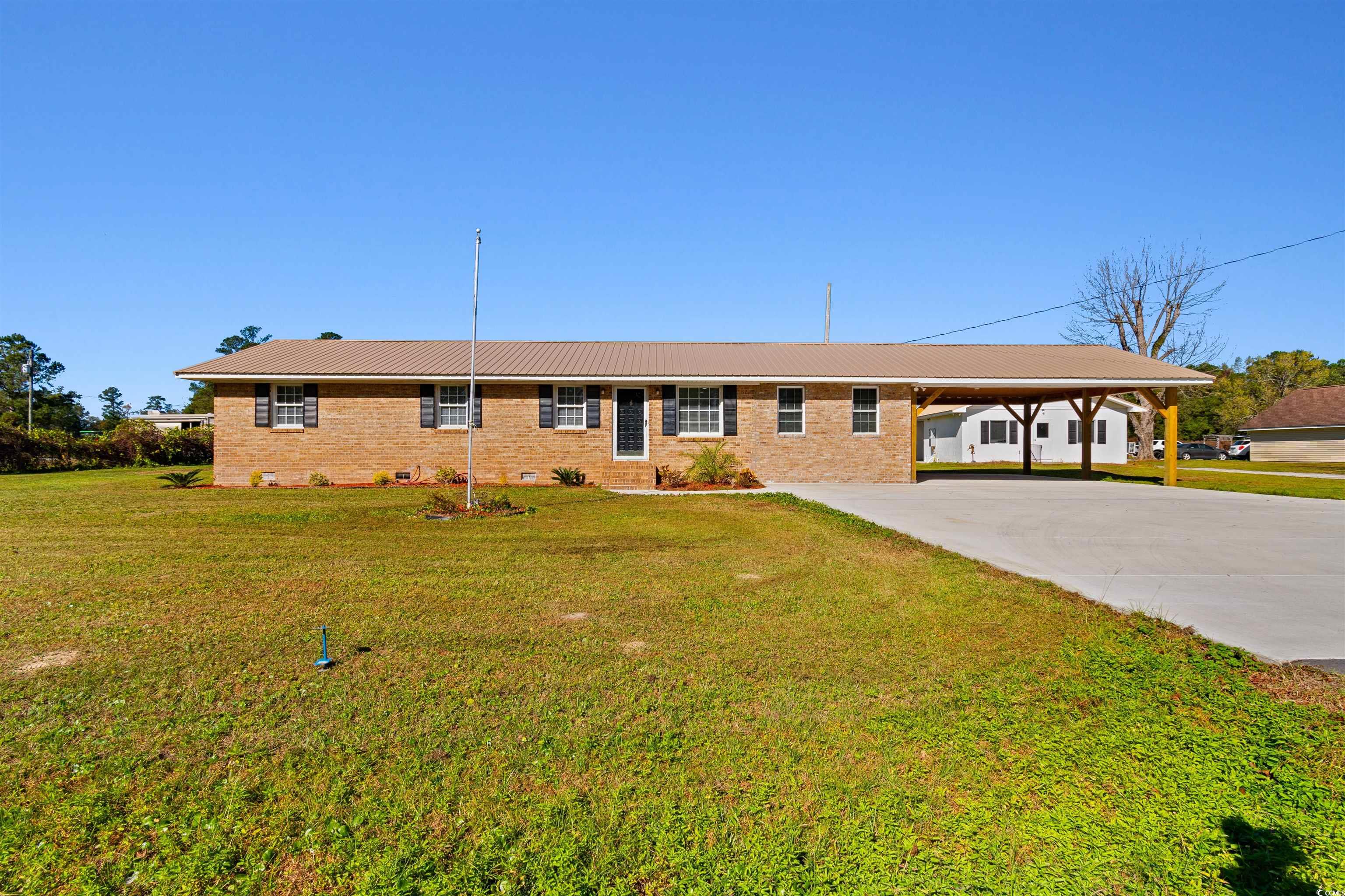 Ranch-style house with a front yard and a carport