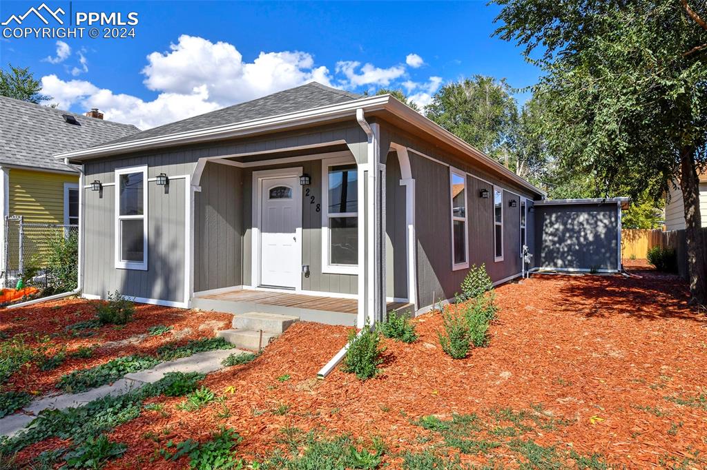 a front view of a house with a yard outdoor seating and covered with yard