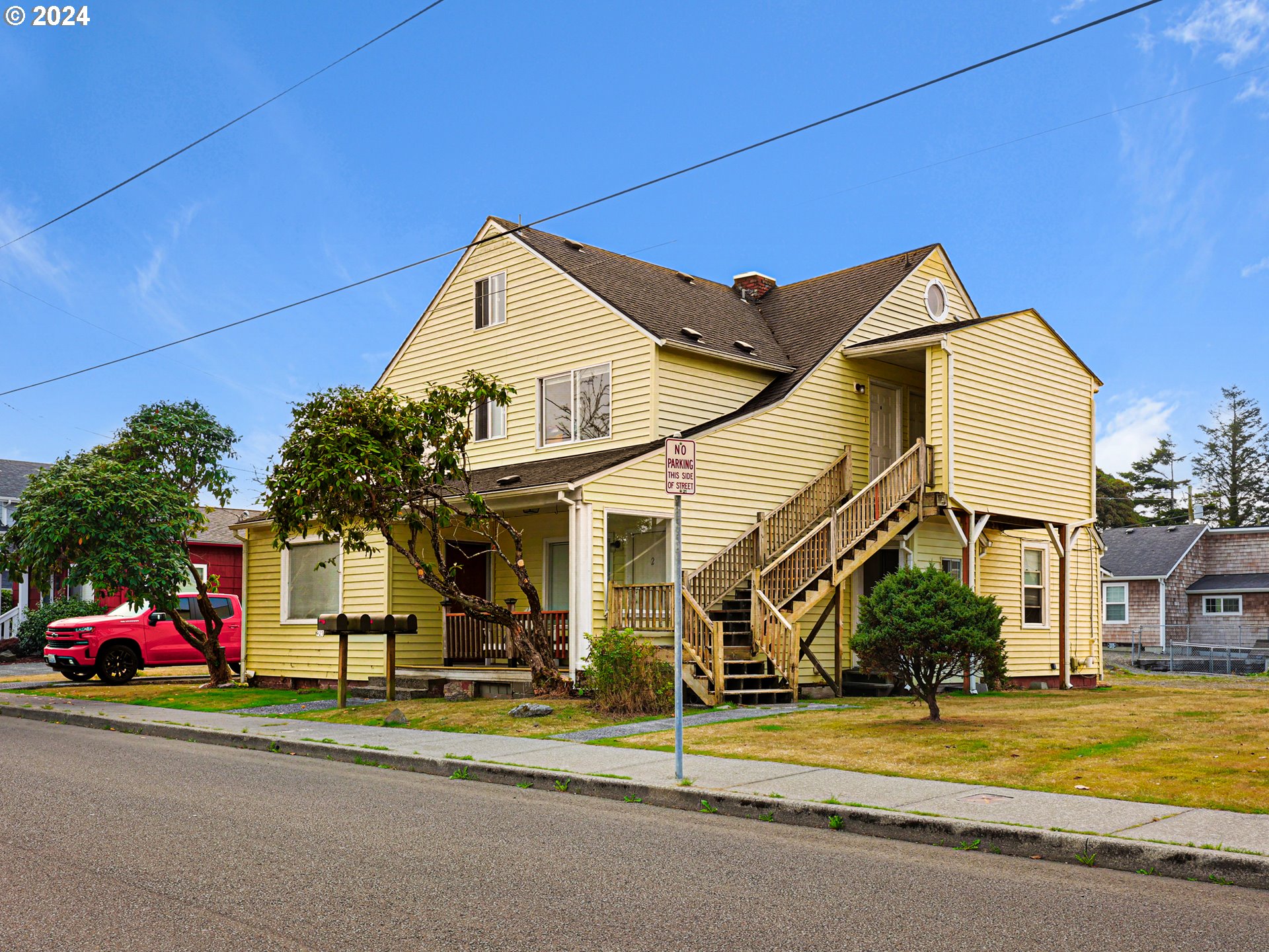 a view of a white house with a small yard and plants