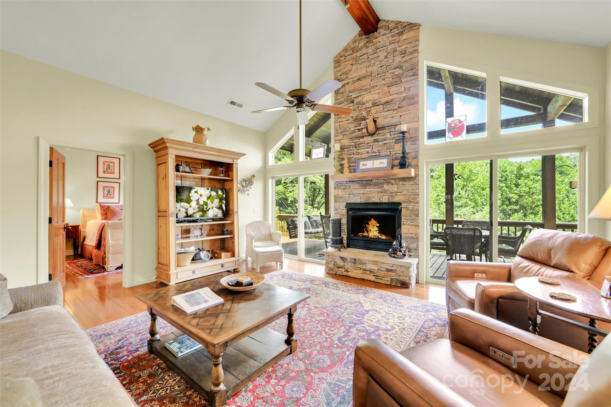 a living room with furniture a fireplace and a floor to ceiling window