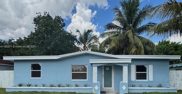 a front view of house with yard and trees around