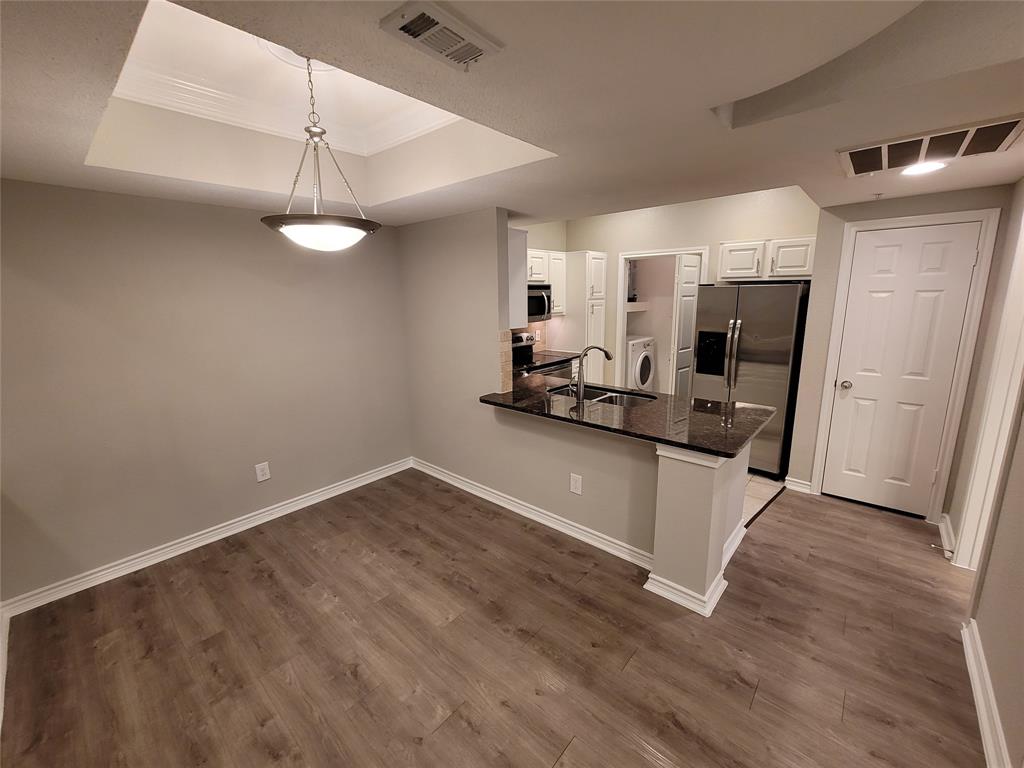 a view of a kitchen with wooden floor and a ceiling fan