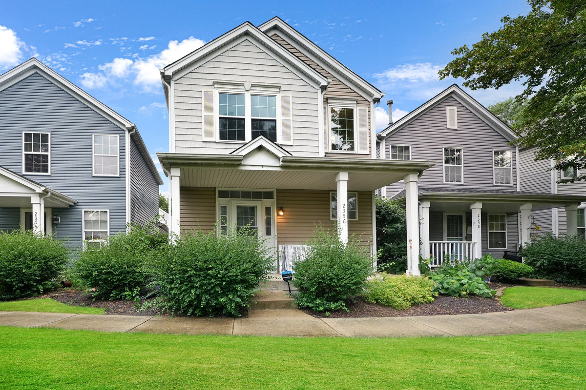 a front view of a house with a yard and potted plants