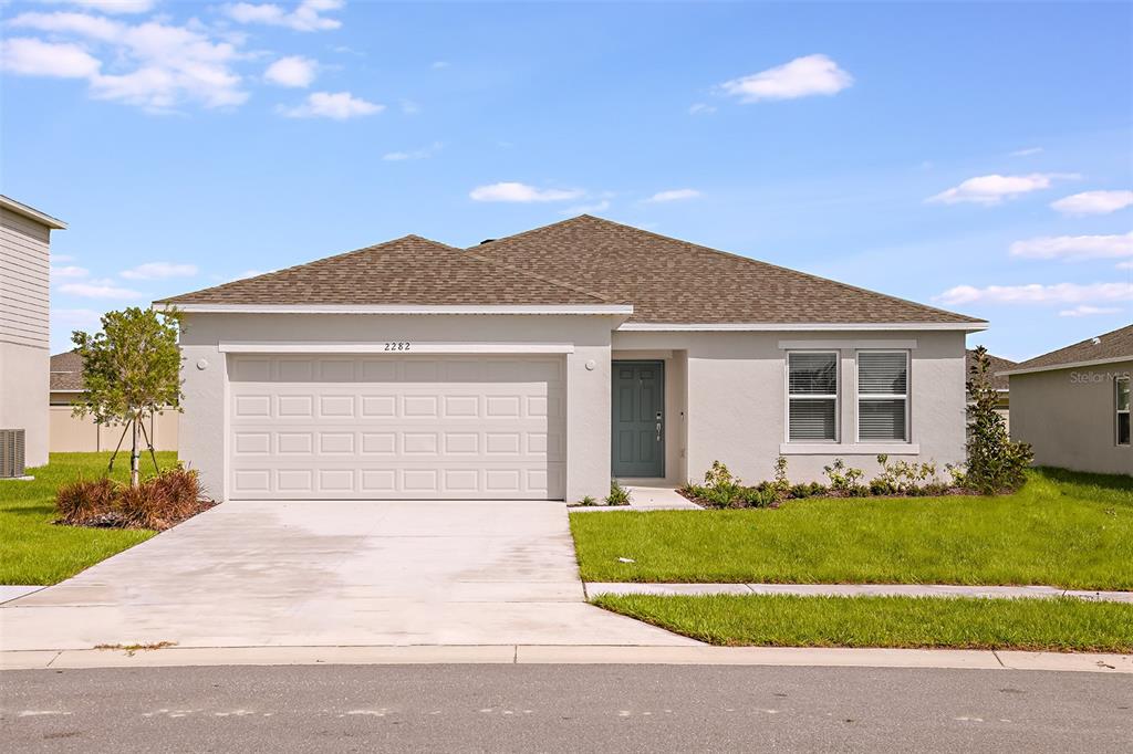 a front view of a house with a yard and garage