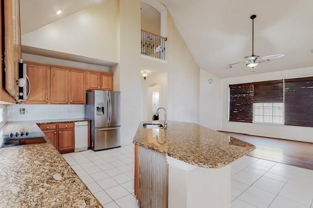 a kitchen with stainless steel appliances granite countertop a sink dishwasher and a refrigerator with wooden floor