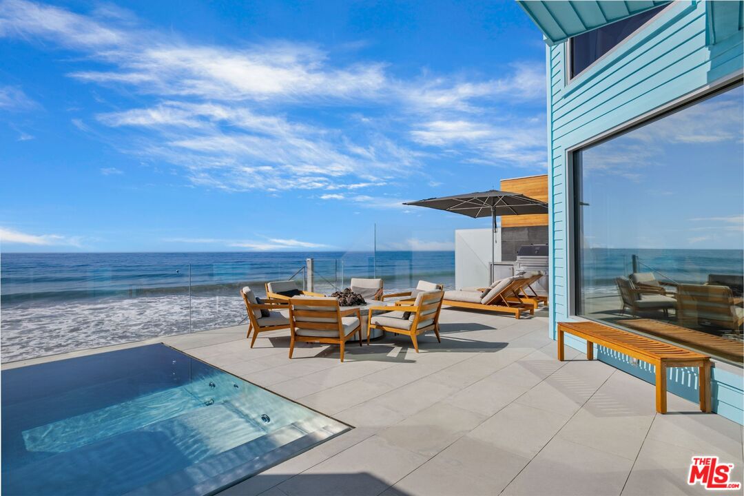 a roof deck with table and chairs and potted plants