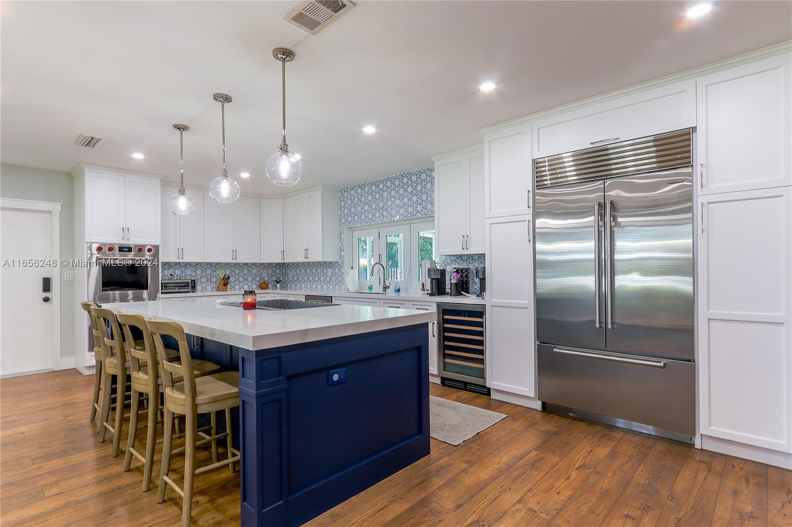 a kitchen with kitchen island a counter top space a sink stainless steel appliances and cabinets