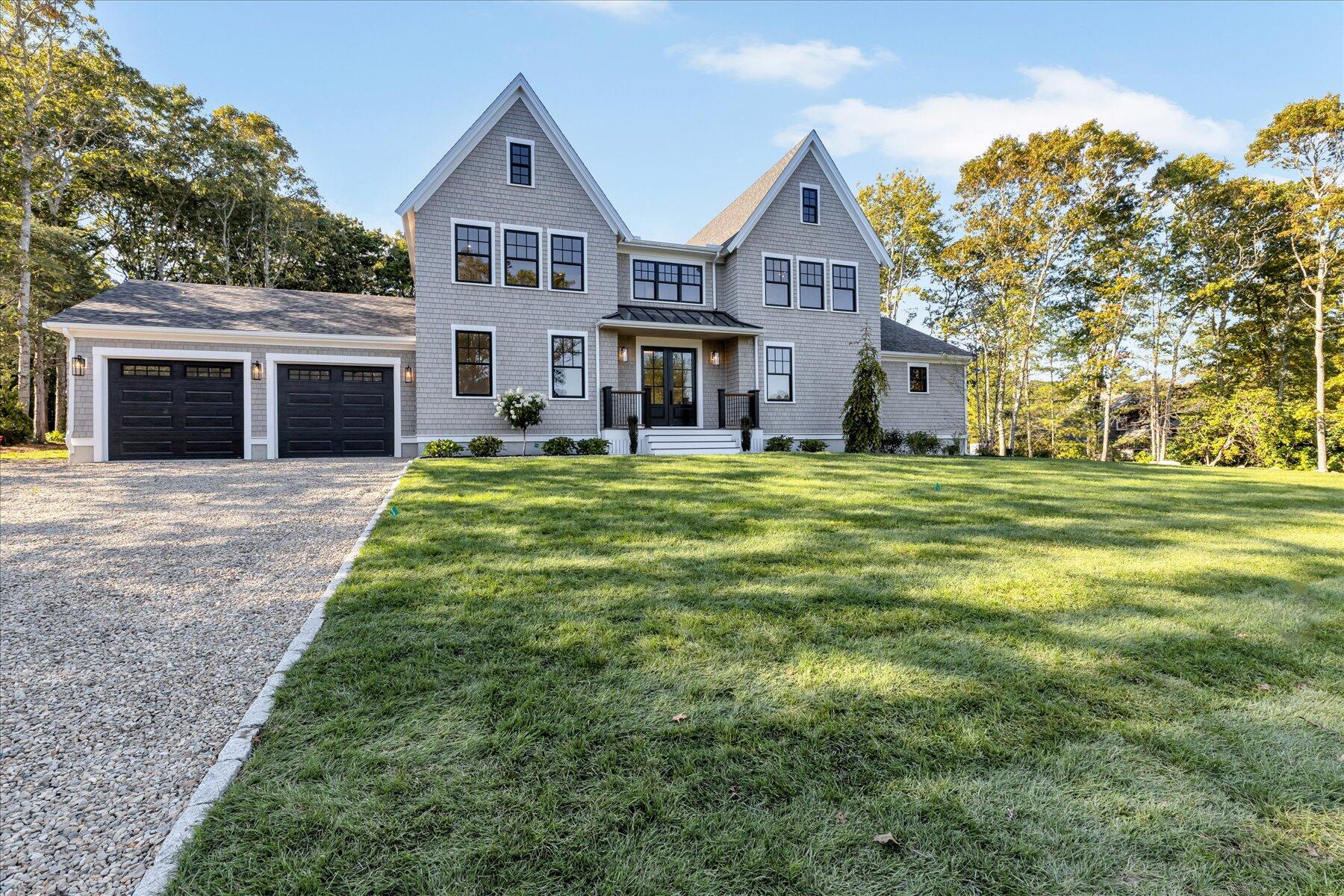 a front view of a house with a yard and trees