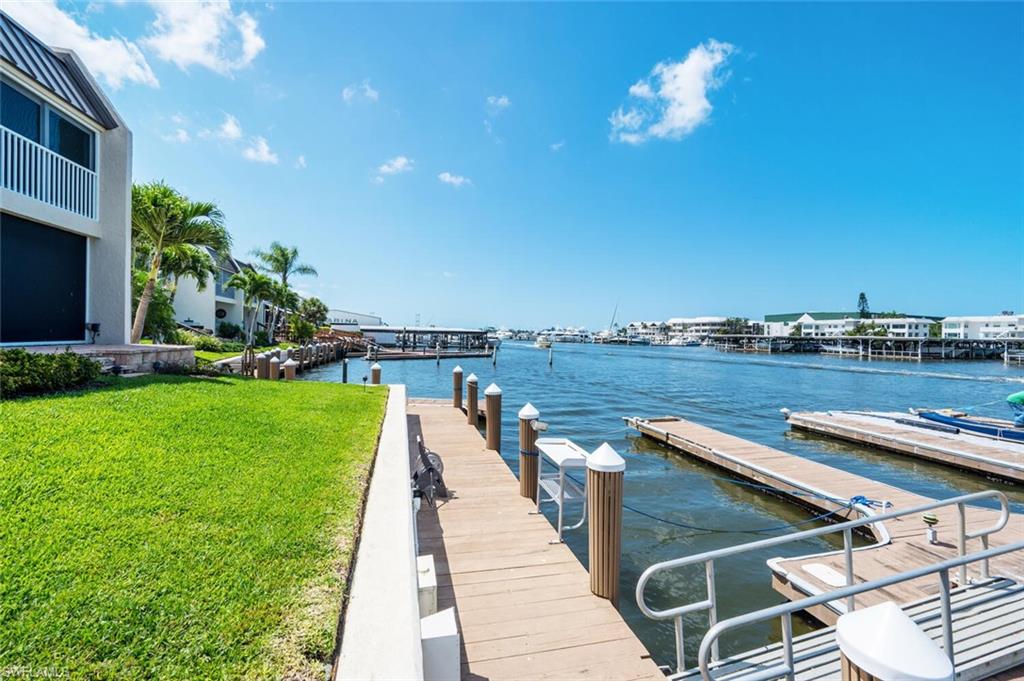 Dock area with a yard and a water view