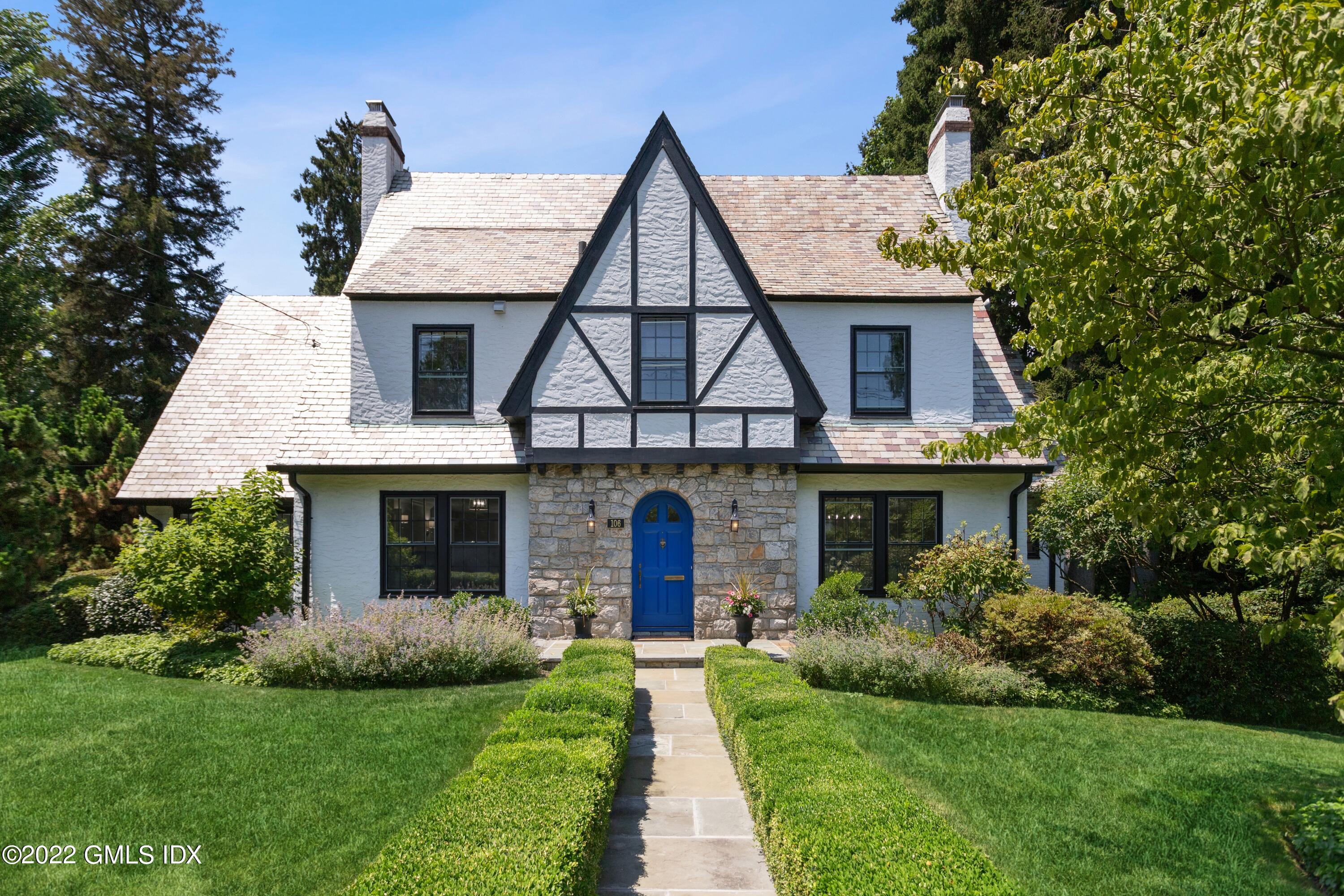 a front view of a house with a garden and plants