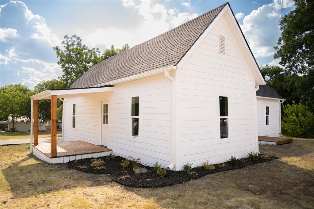 a view of a white house next to a yard