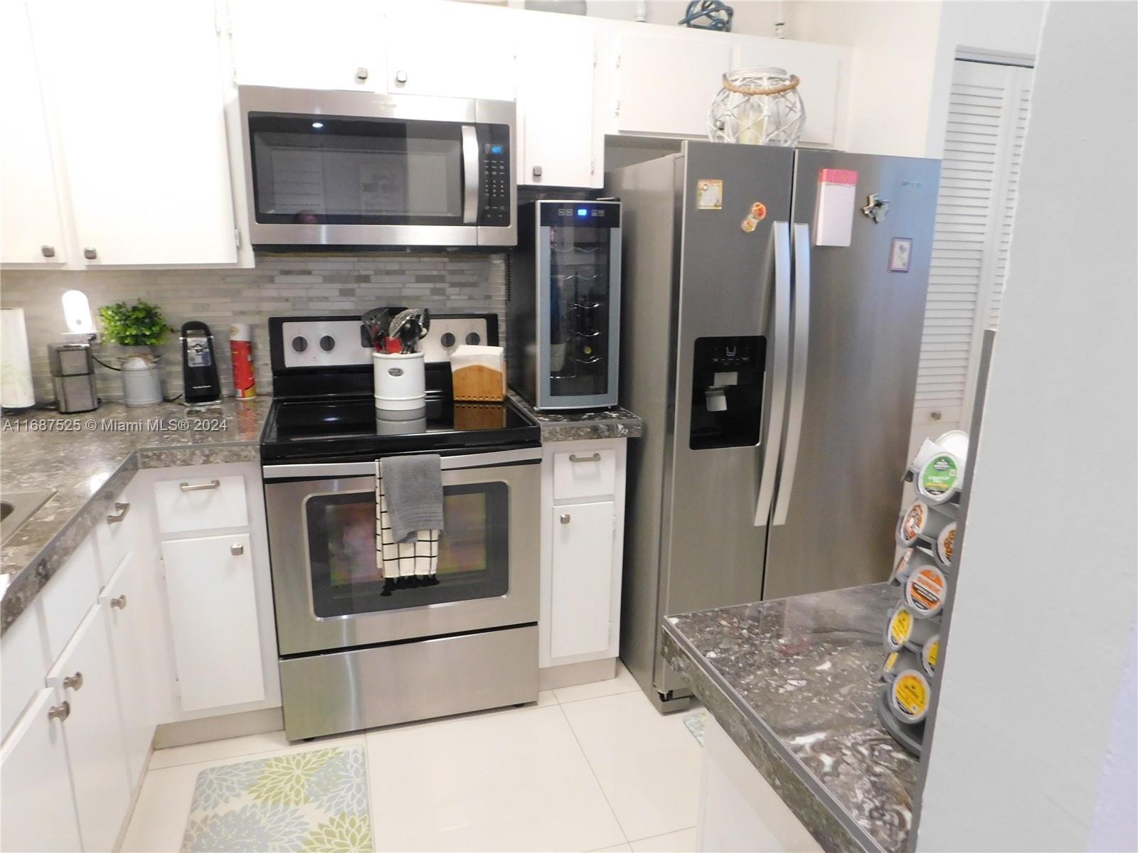 a kitchen with stainless steel appliances granite countertop a refrigerator stove and sink