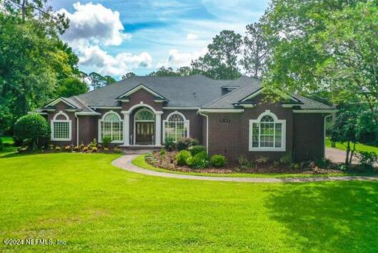 a front view of a house with a garden and yard