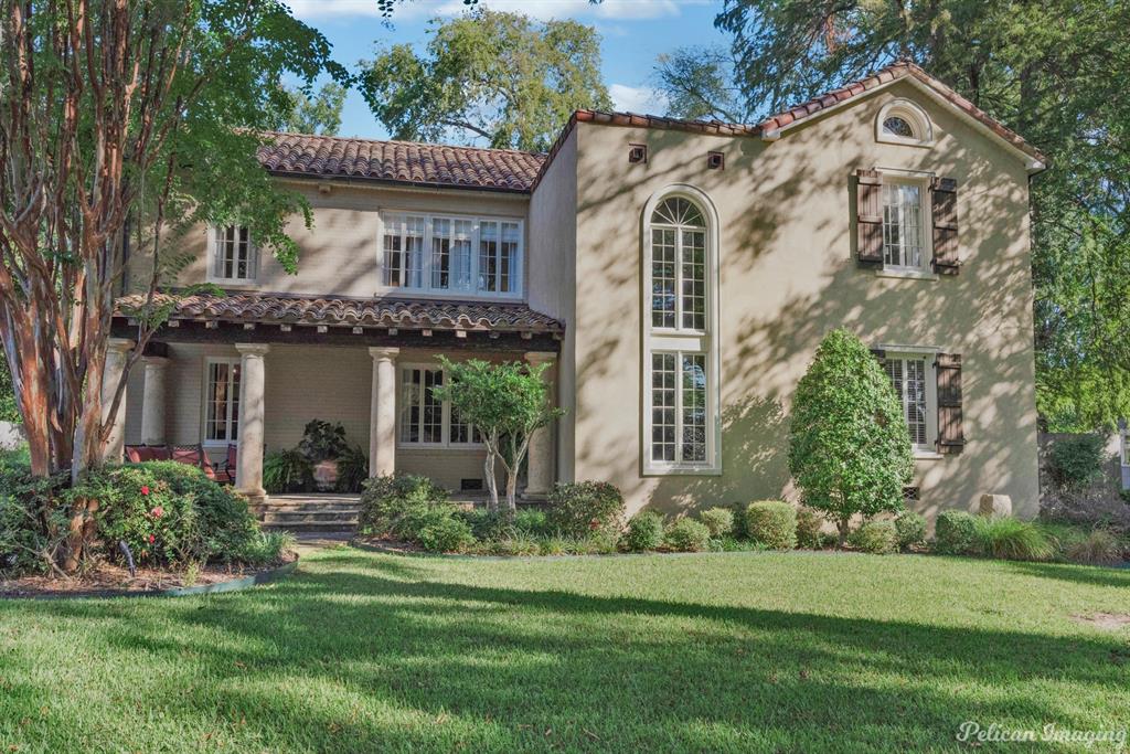 a view of a white house with a big yard and potted plants