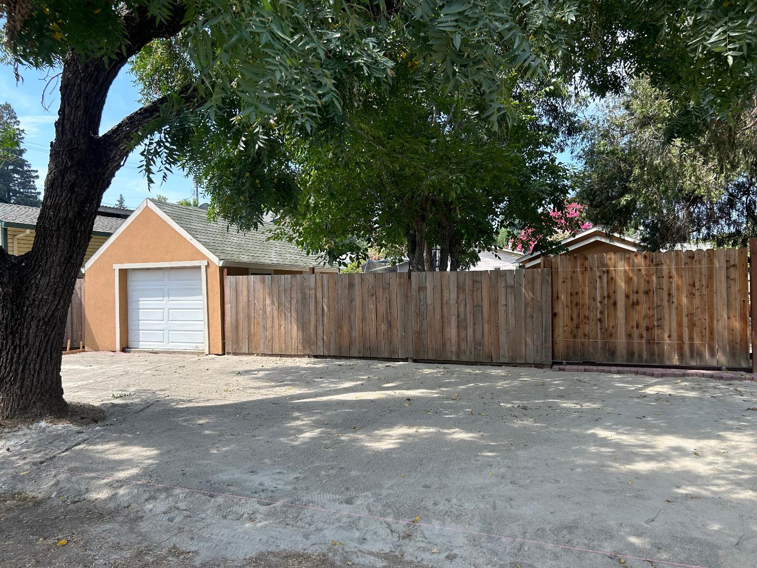 a view of a house with a yard and large trees