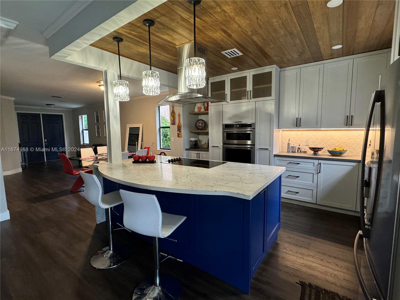 a kitchen with granite countertop a table chairs stainless steel appliances and cabinets