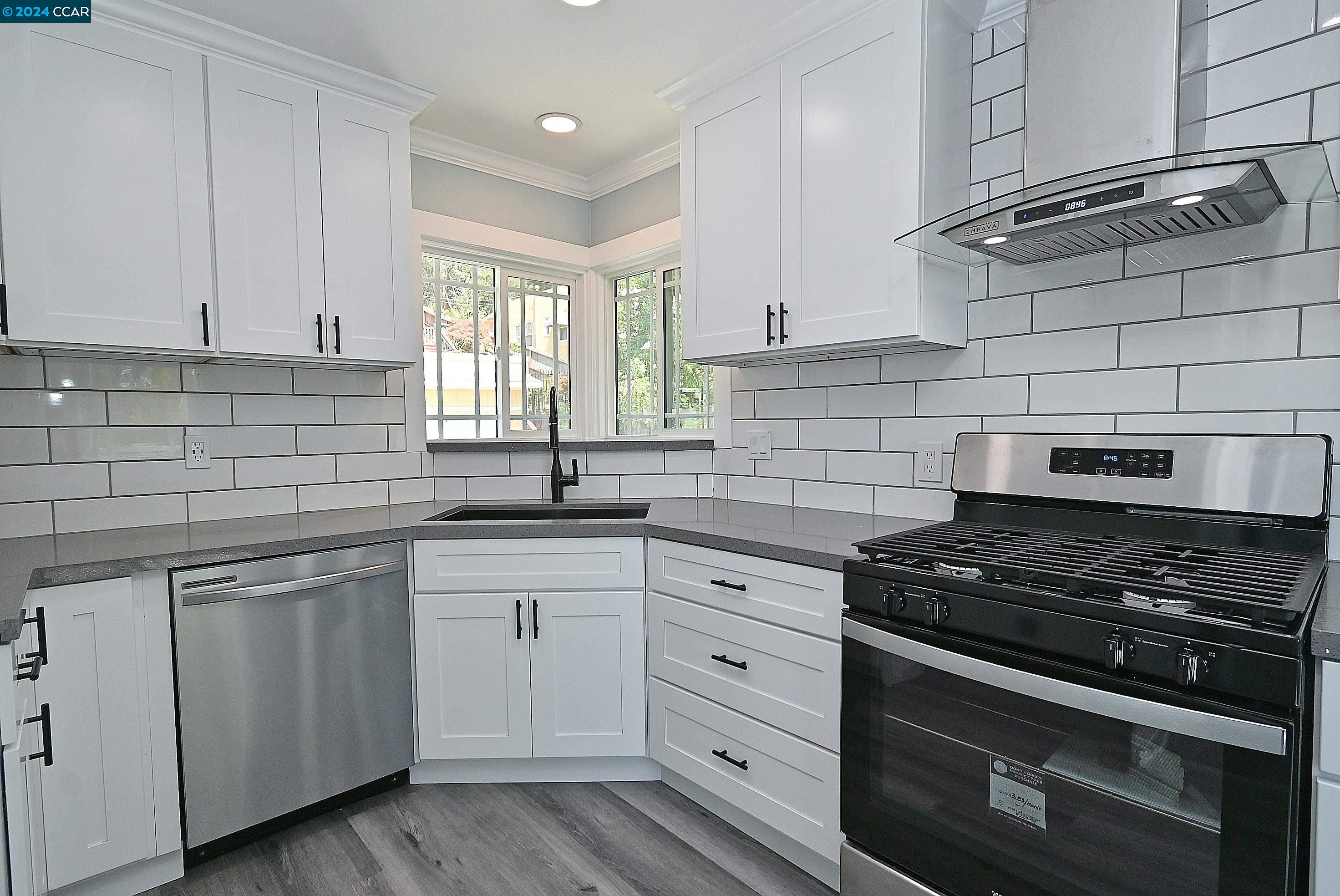 a kitchen with white cabinets and appliances