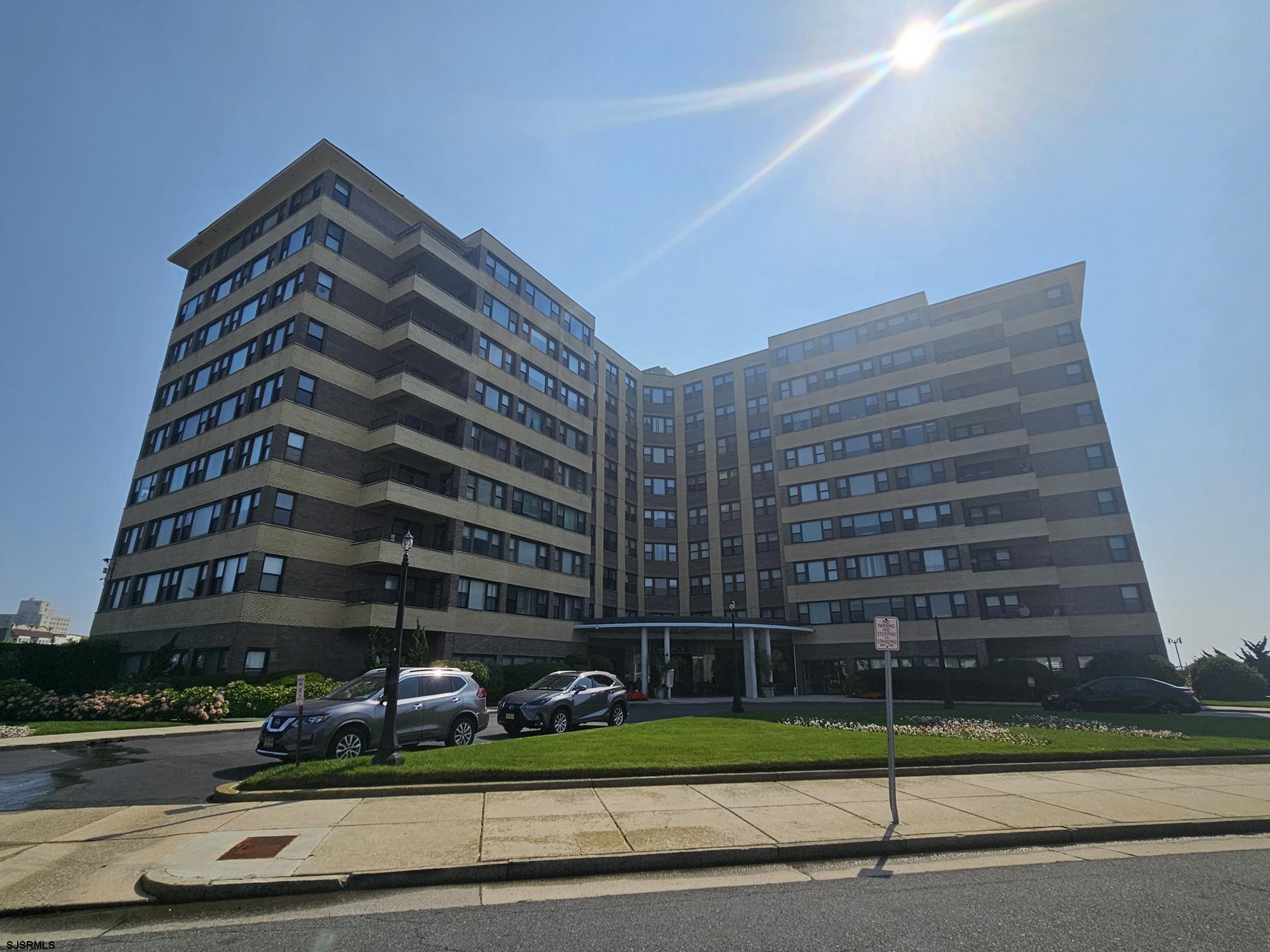 a view of a tall building next to a yard