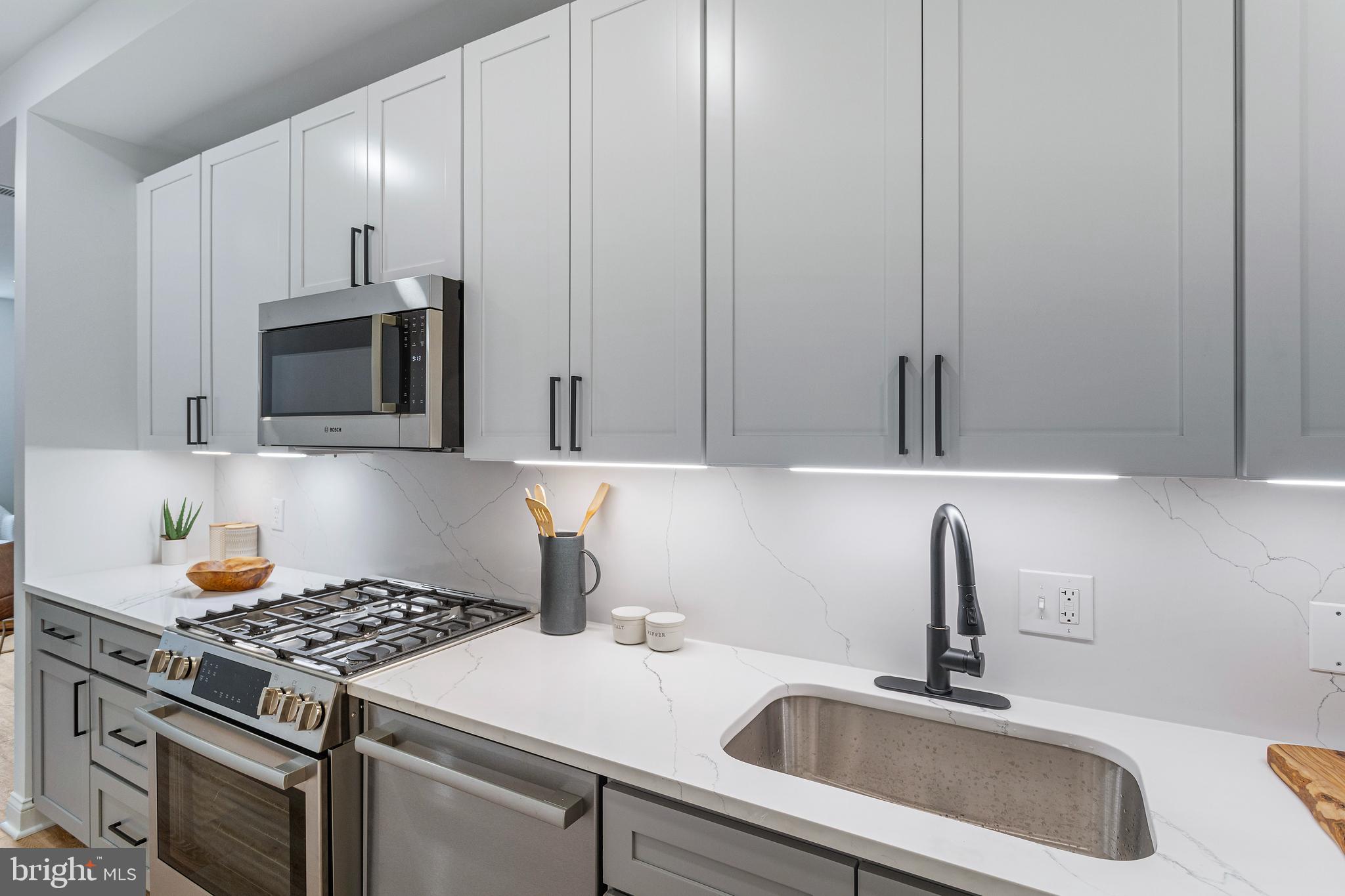 a kitchen with a sink stove and microwave