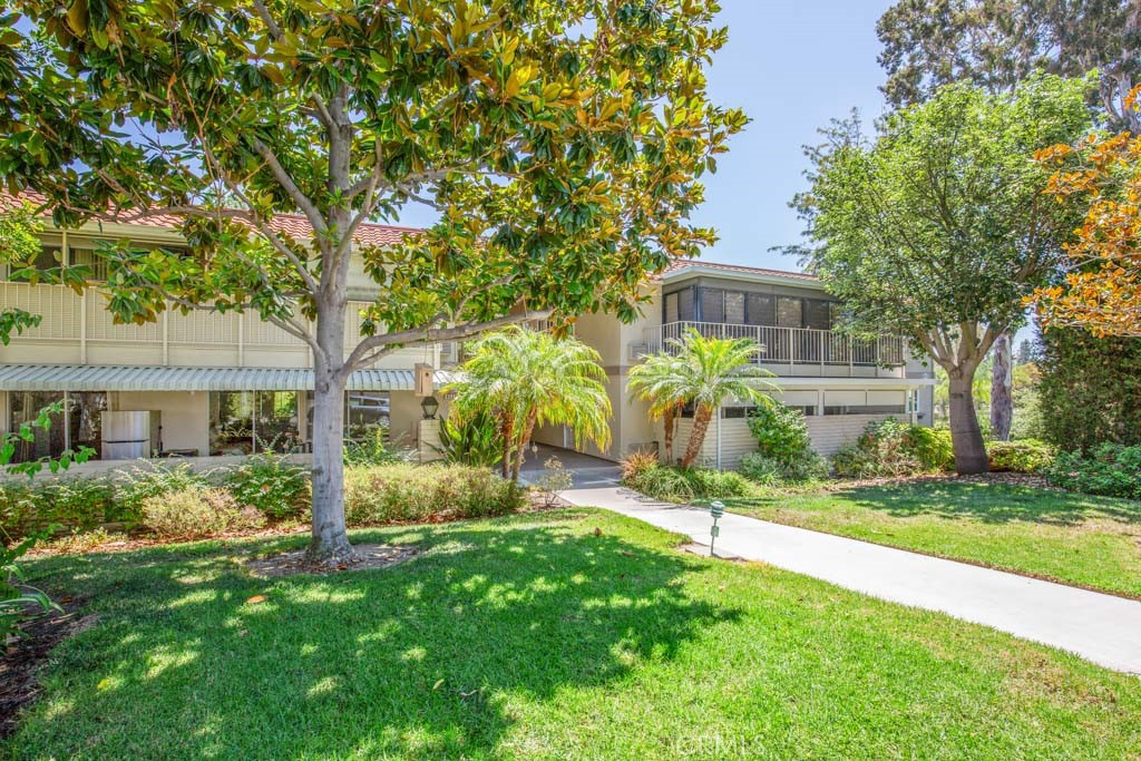 a view of a house with backyard and a tree