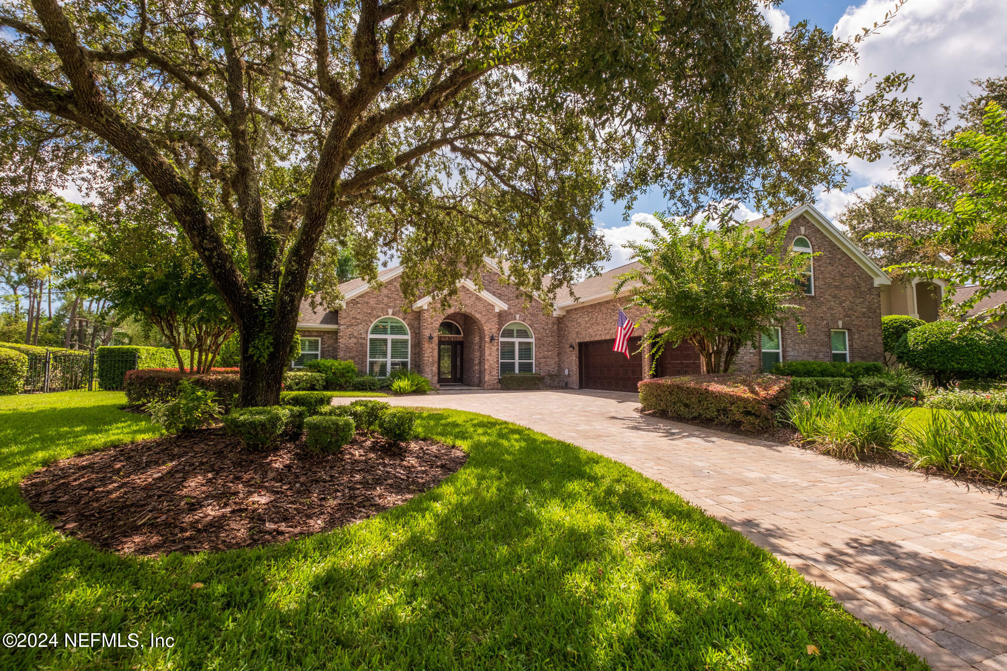 a front view of a house with a yard and trees