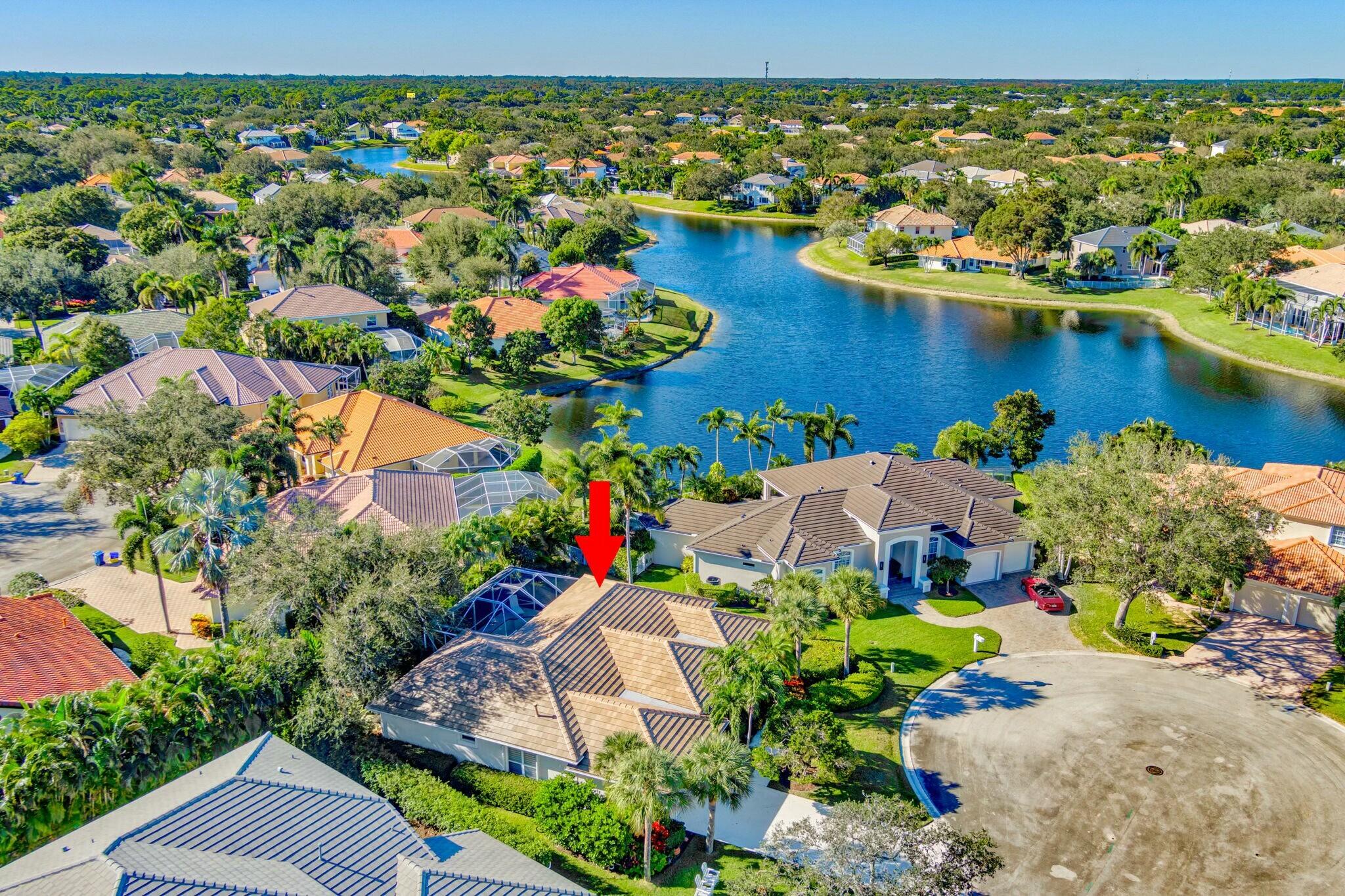 an aerial view of a house with a garden and lake view