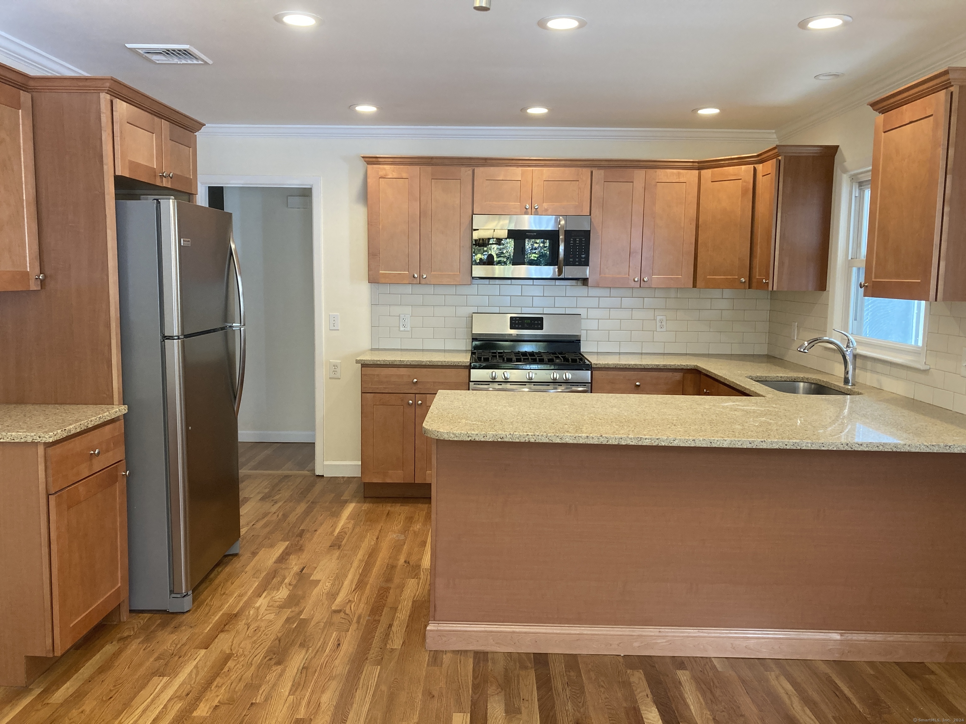 a kitchen with stainless steel appliances a refrigerator sink and microwave