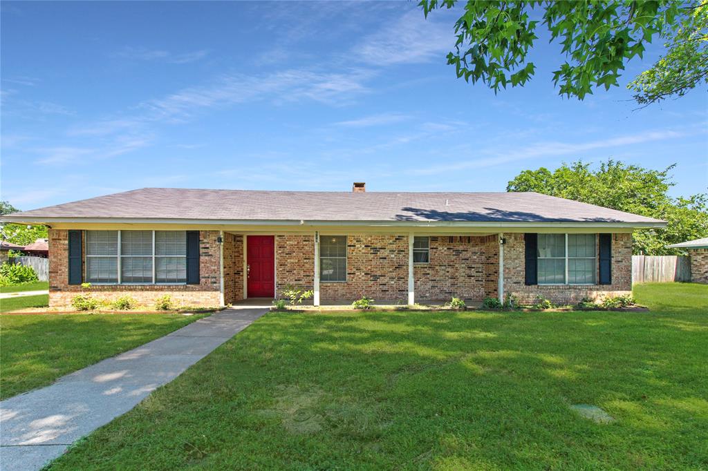 a front view of a house with a garden and trees