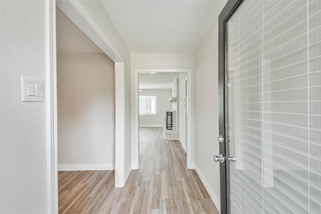 a view of a room with wooden floor a ceiling fan and bathroom