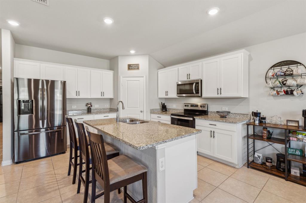 a kitchen with granite countertop stainless steel appliances and white cabinets