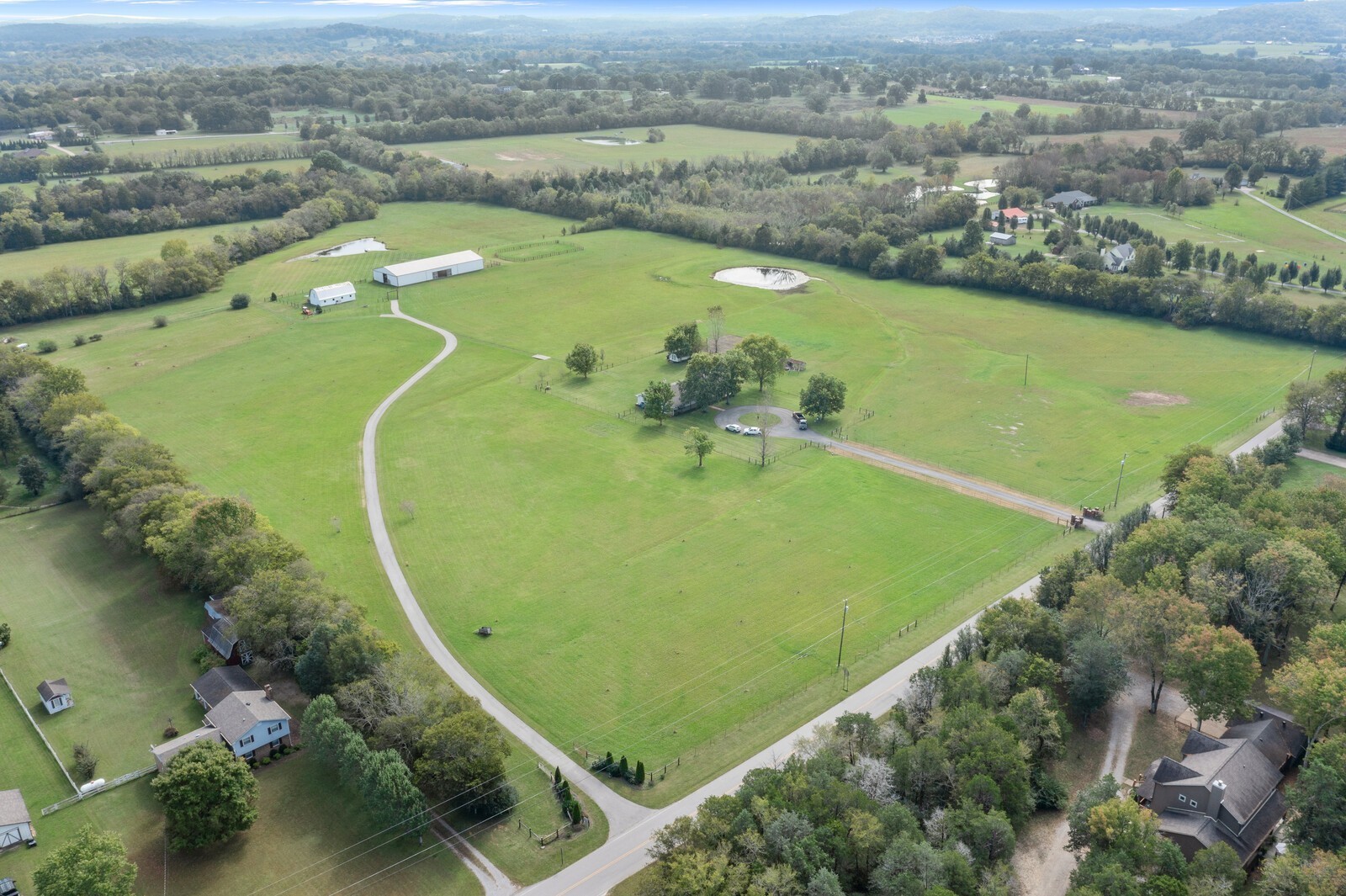 an aerial view of a residential houses with outdoor space and river