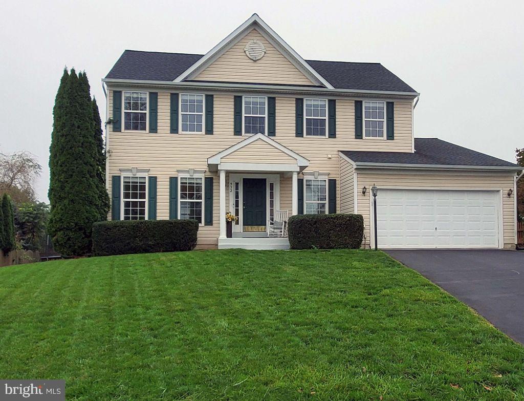 a front view of a house with yard and green space