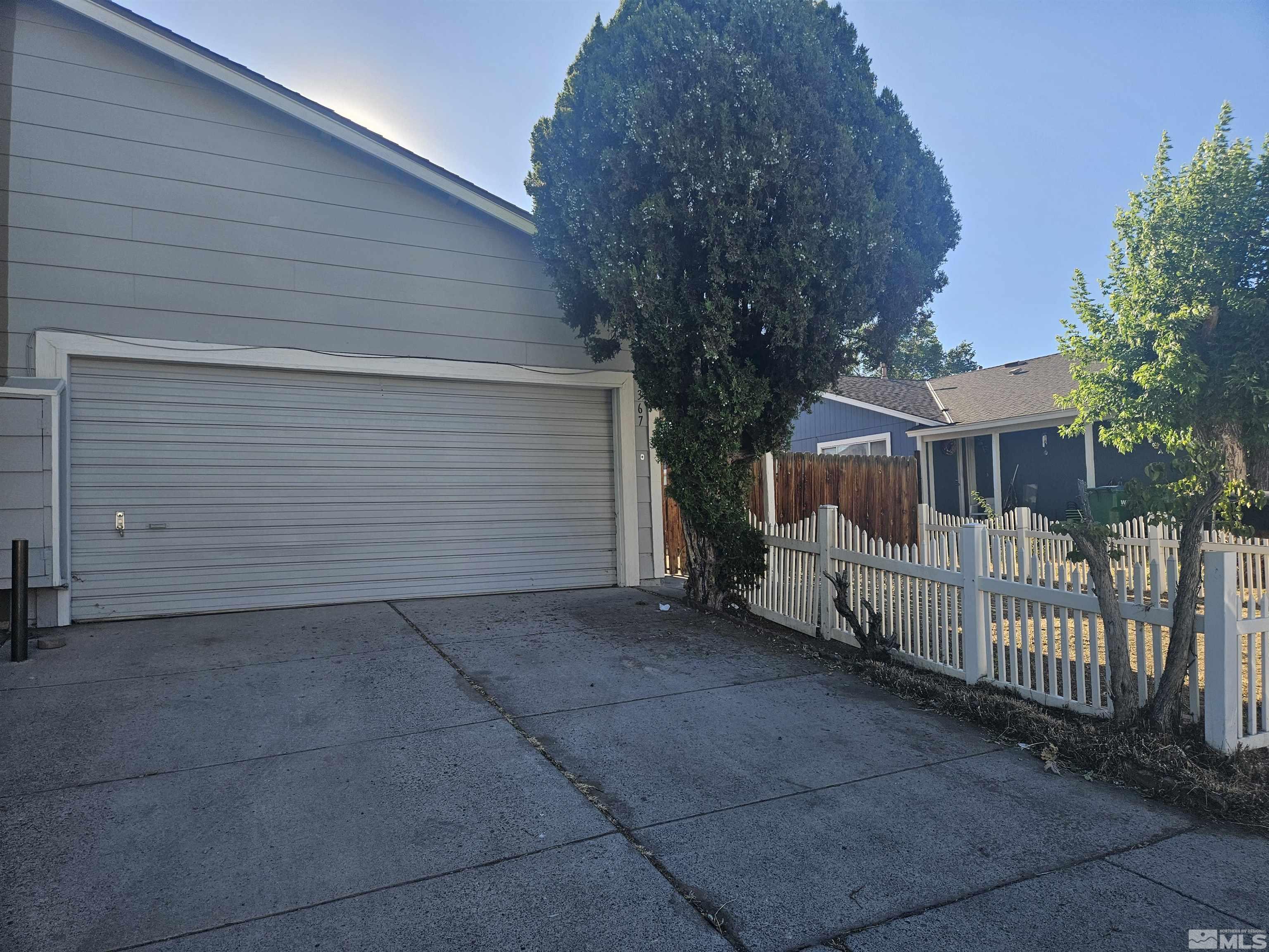 a view of a house with a small yard and wooden fence