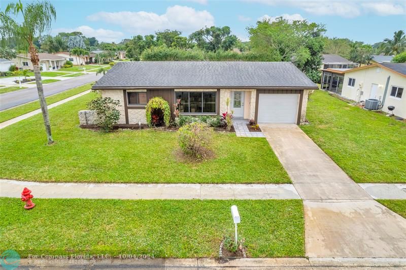 a aerial view of a house with swimming pool and a yard