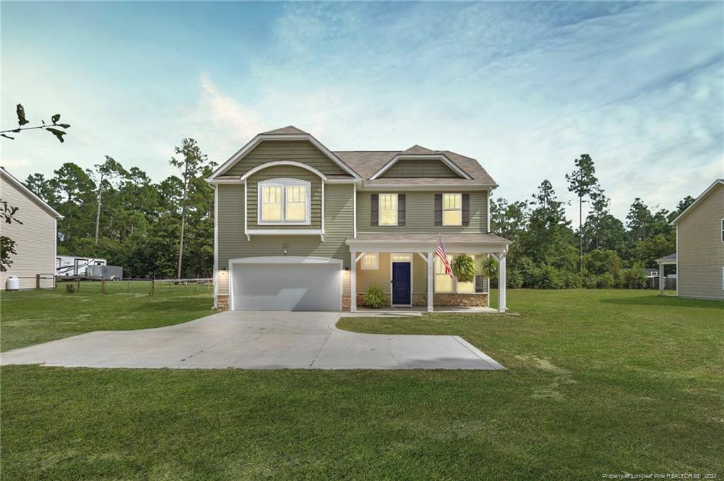 a front view of a house with a yard and trees