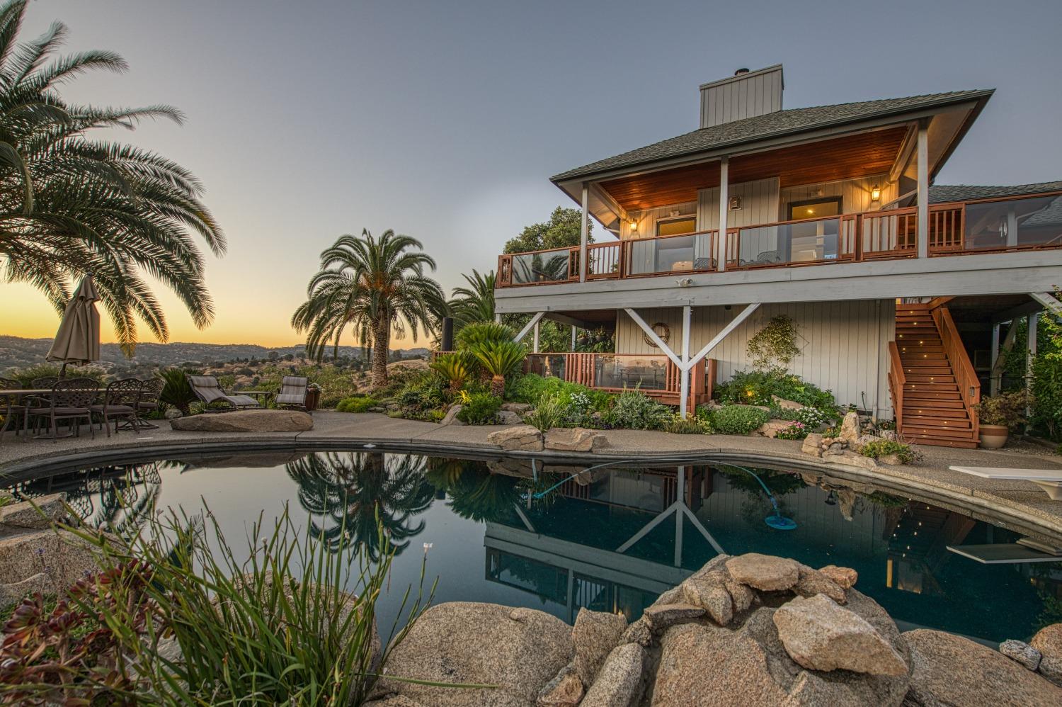 a view of a house with pool and chairs