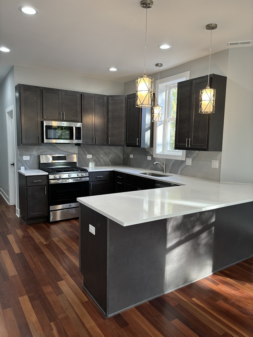 a kitchen with kitchen island granite countertop a sink appliances and cabinets