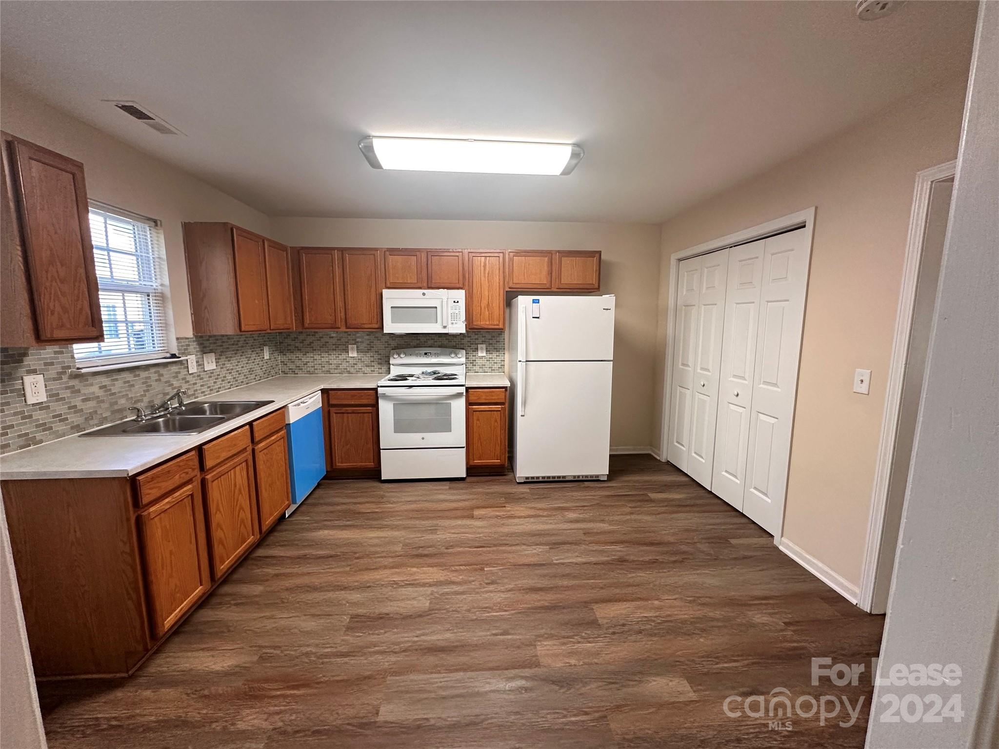 a kitchen with a refrigerator a stove top oven a sink and dishwasher