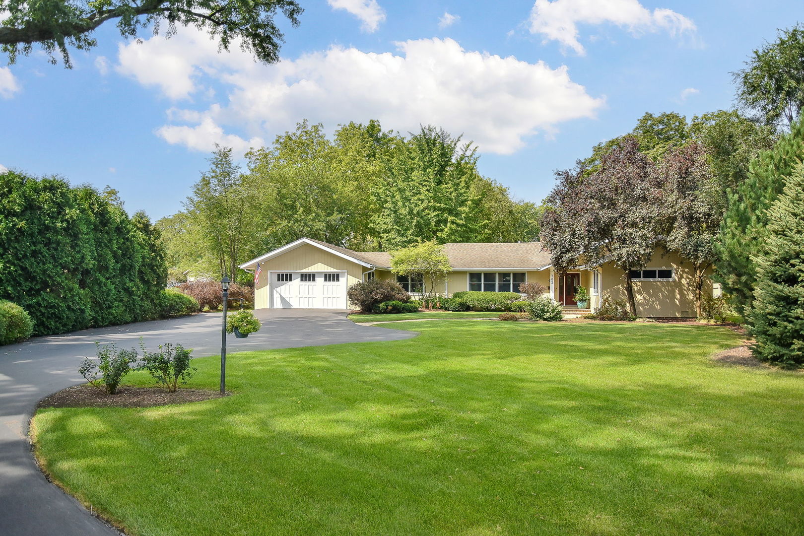 a front view of a house with a garden and yard