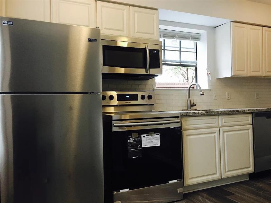 a kitchen with a refrigerator stove and microwave