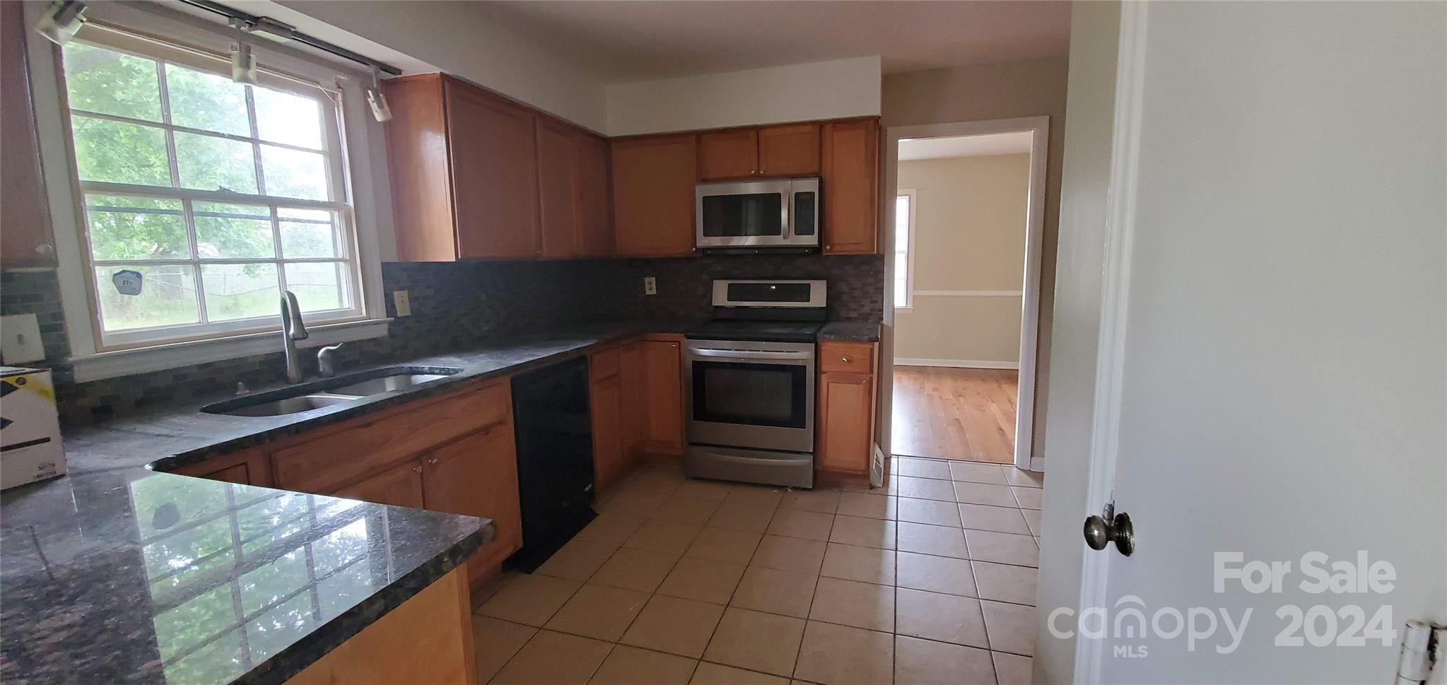 a kitchen with stainless steel appliances granite countertop a sink and a stove