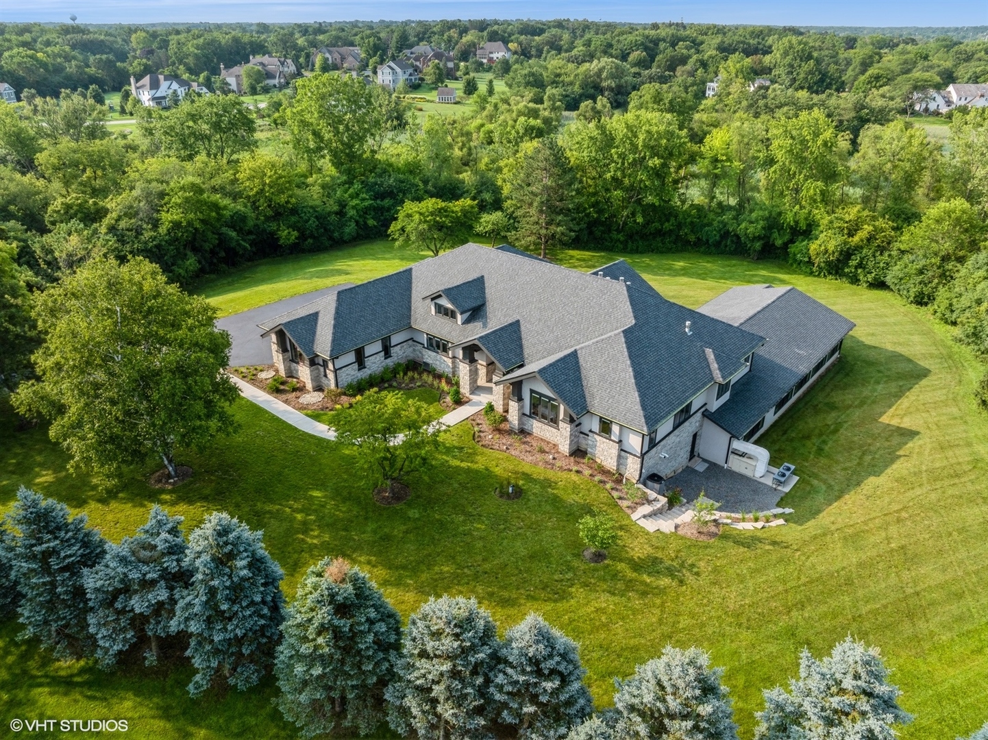 an aerial view of a house with pool big yard and large trees