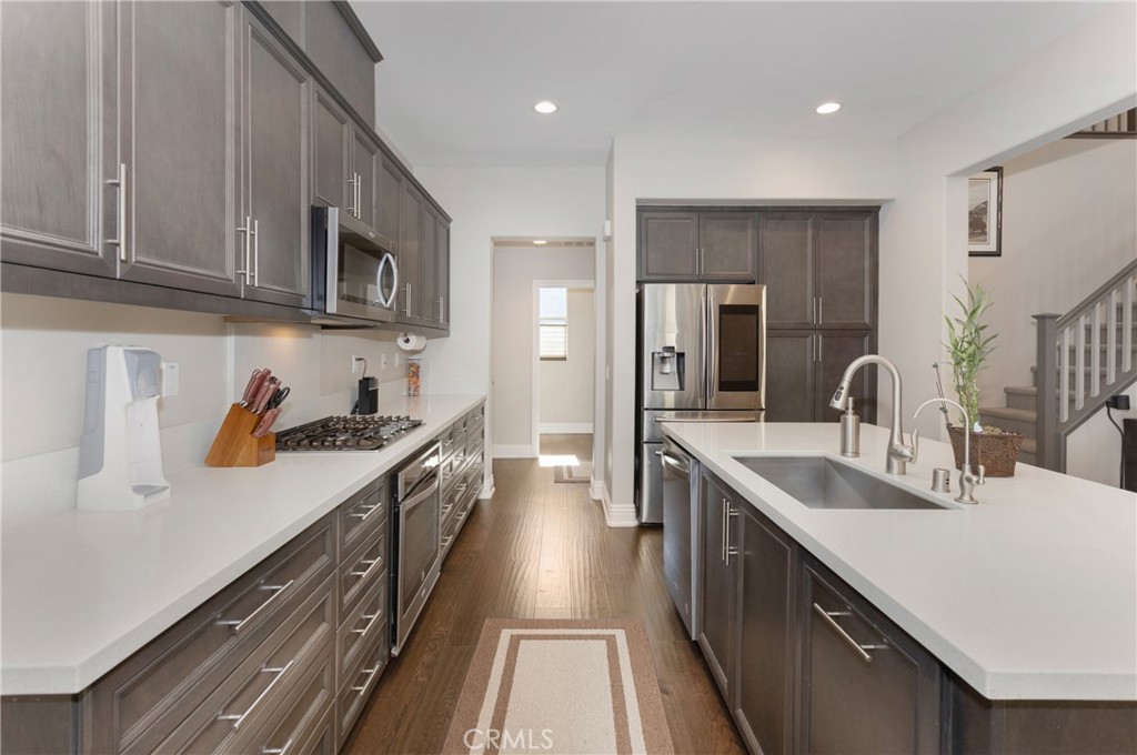 a large kitchen with stainless steel appliances granite countertop a lot of counter space and wooden floor