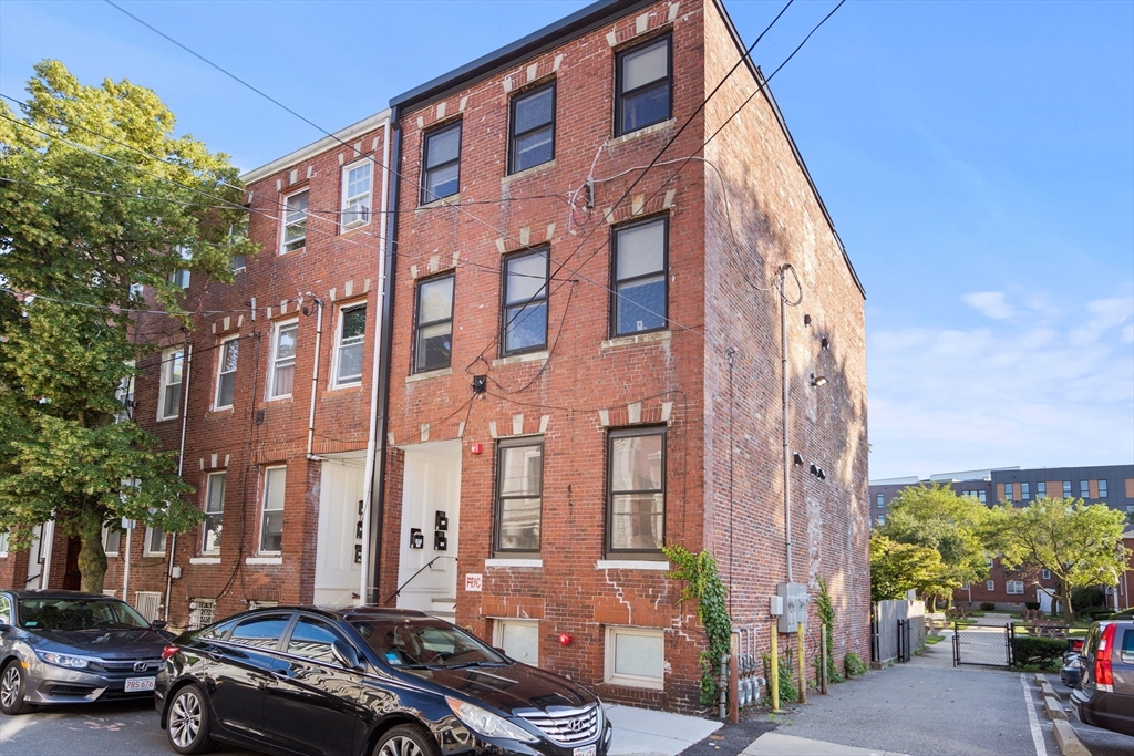 a couple of cars parked in front of brick building