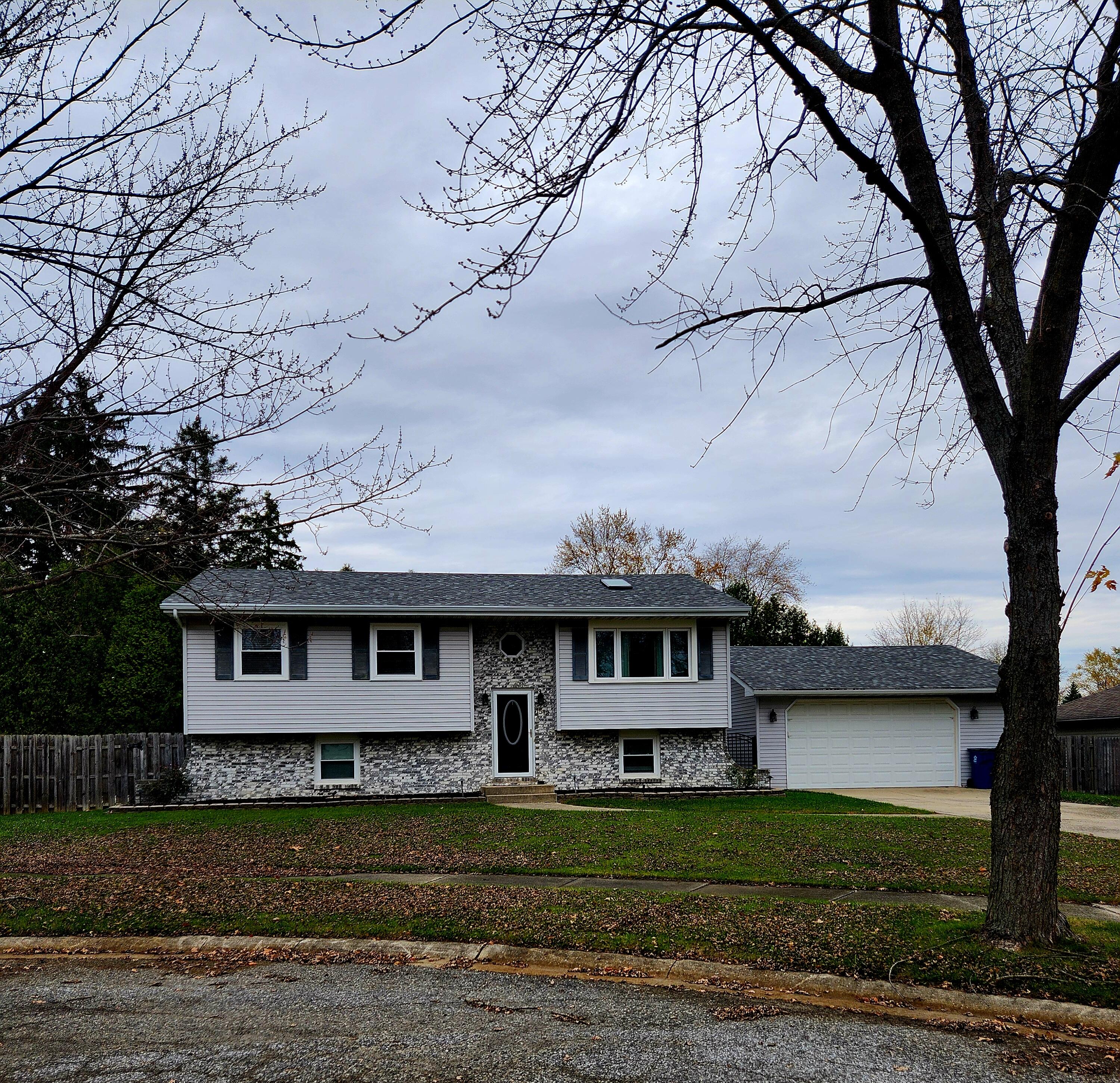 a view of a big house with a big yard and large trees