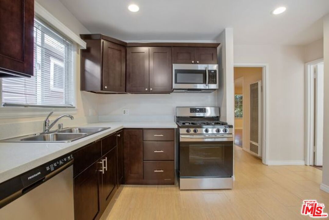 a kitchen with stainless steel appliances granite countertop a sink stove and refrigerator