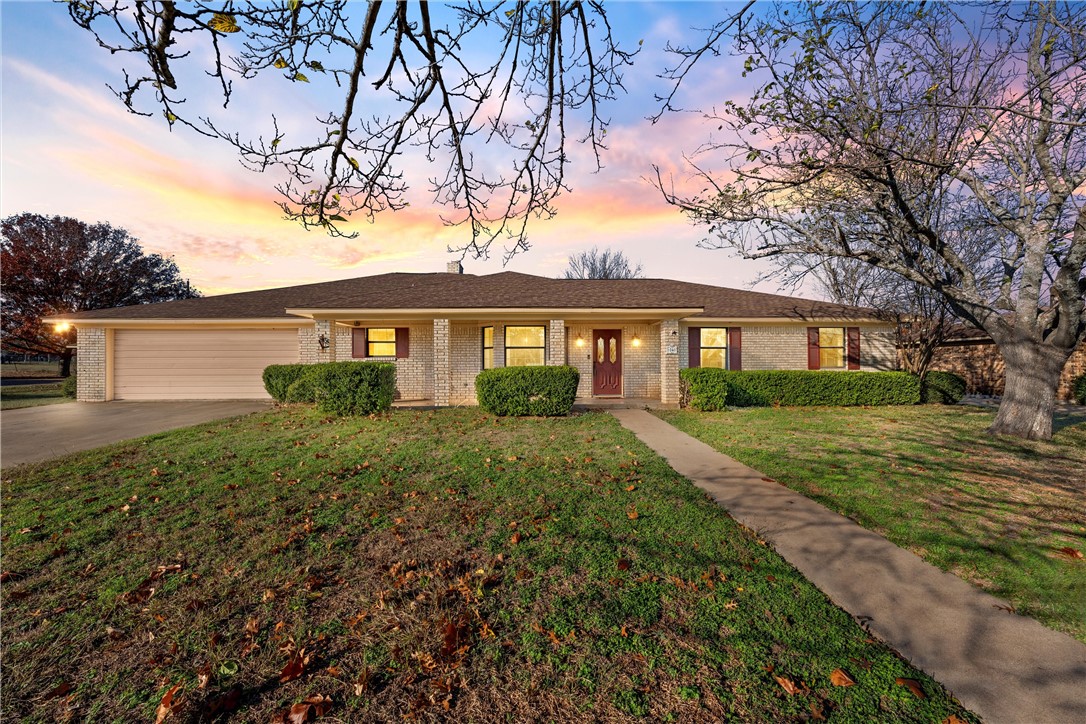 a front view of a house with yard and green space